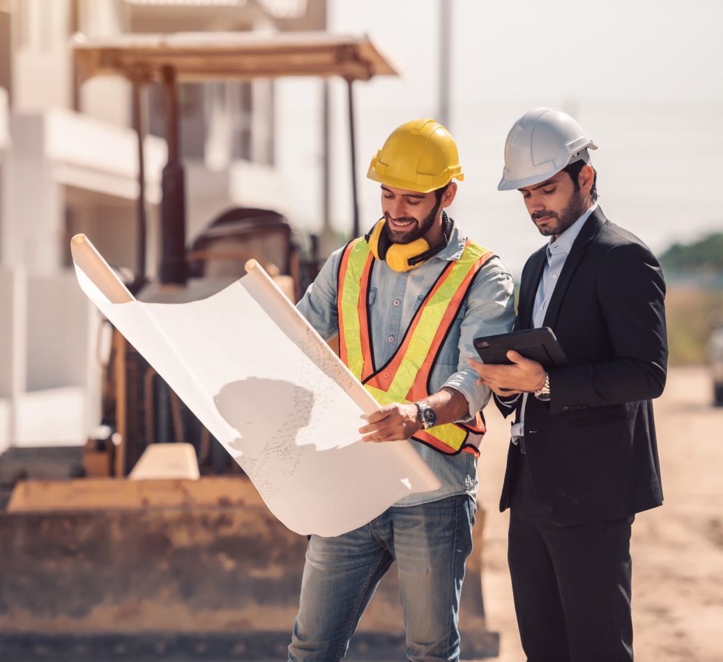 Civil engineer and construction worker manager holding digital tablet and blueprints , talking and planing about construction site.  Cooperation teamwork concept.